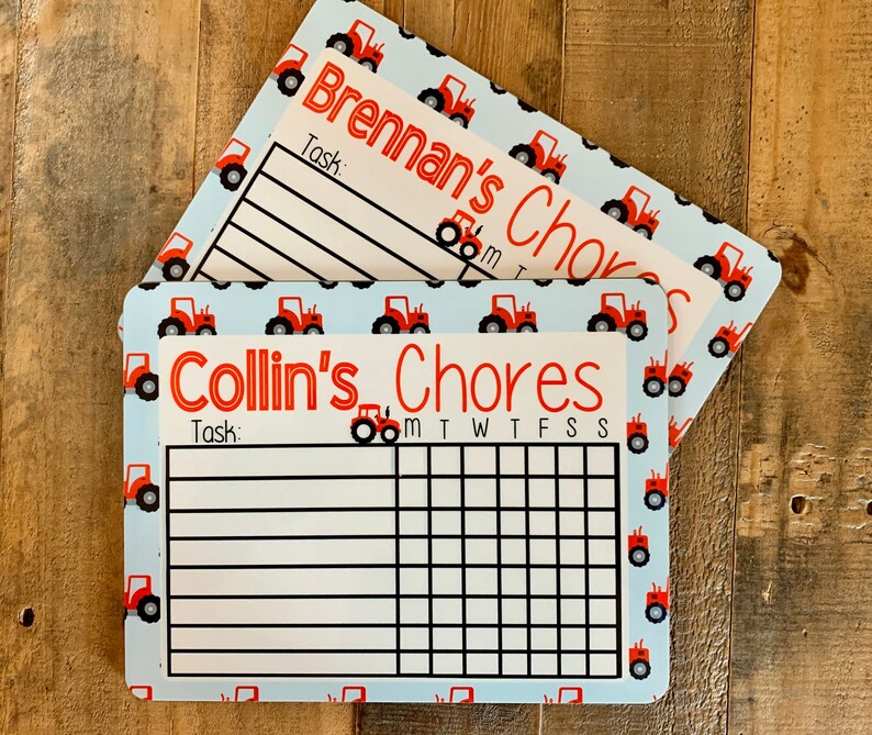 K&ouml;nnte beinhalten: Zwei blaue und wei&szlig;e Aufgabenkarten mit roten Traktor-Illustrationen. Die obere Karte lautet "Brennan's Chores" und die untere Karte lautet "Collin's Chores". Beide Karten haben einen Platz f&uuml;r eine Aufgabe und ein Raster f&uuml;r jeden Tag der Woche.