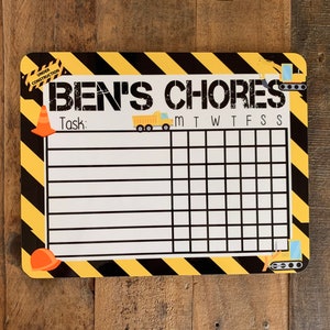 K&ouml;nnte beinhalten: Ein gelber und schwarzer Bau-Chore-Chart mit dem Text "BEN'S CHORES" oben. Der Chart hat einen Platz zum Schreiben von Aufgaben und ein Raster zum Abhaken der Wochentage.