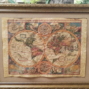 Könnte beinhalten: Ein rechteckiger goldfarbener Rahmen mit einer verzierten, strukturierten Bordüre, der eine Weltkarte im Vintage-Stil auf gealtertem, beigefarbenem Papier enthält. Die Karte zeigt zwei kreisförmige Hemisphären mit detaillierter Kartografie.