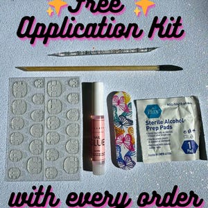 Op de afbeelding: Gratis applicatieset voor press-on nagels. De set bevat een flesje nagellijm, een vijl, een pakje alcohol prep pads en een vel met plakstrips. De set wordt bij elke bestelling meegeleverd.