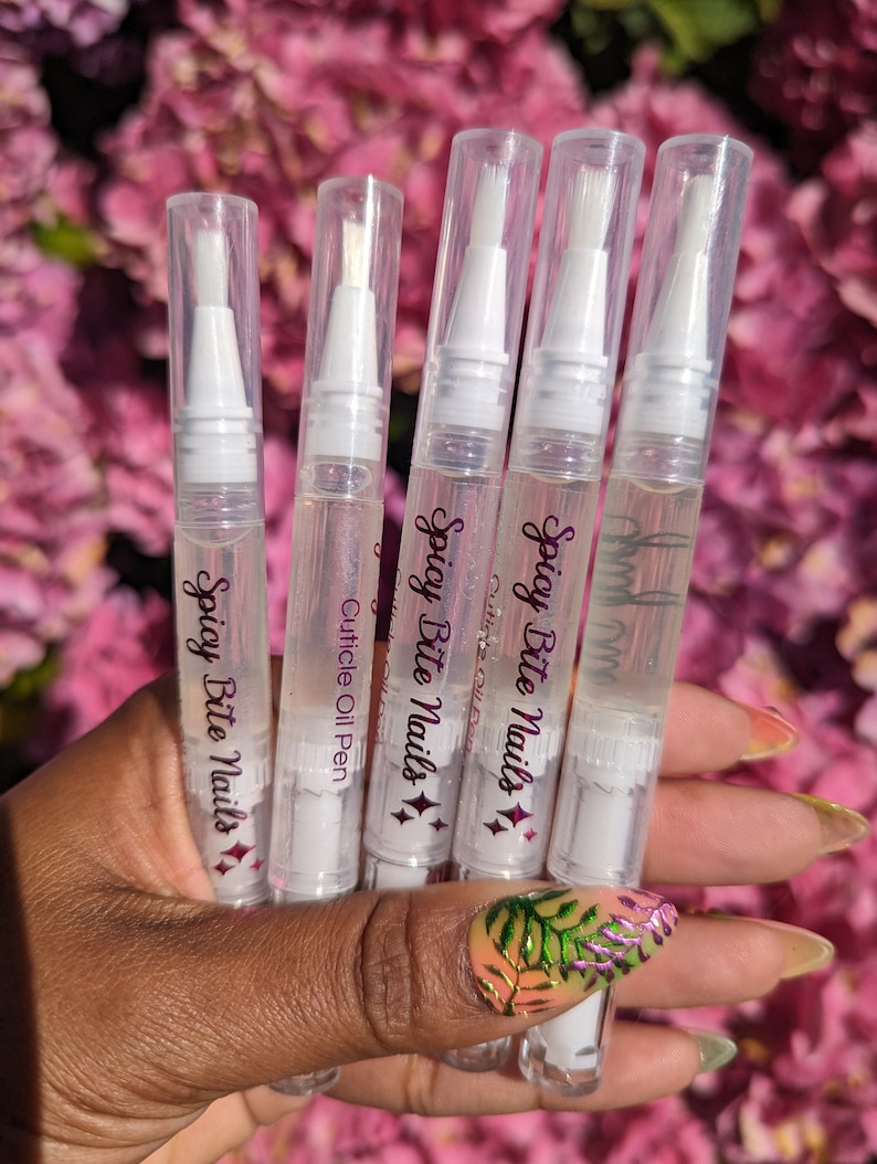 May include: Five clear plastic bottles with white caps and applicators. Each bottle contains a clear liquid and has the text "Spicy Bite Nails" and a diamond design printed on the label.