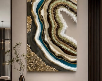 May include: A rectangular wall art piece featuring a geode-inspired design with concentric layers of teal, white, black, and gold. The artwork incorporates textured gold leaf accents and a central cluster of white crystalline structures.