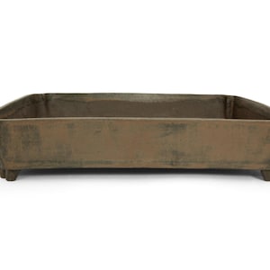 May include: A rectangular, brown planter with a weathered appearance. The planter has a low profile, raised sides, and sits on four small feet. The color is a mix of brown and green, suggesting an aged, outdoor aesthetic.
