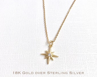 Può includere: Una collana d'oro con un ciondolo a forma di stella con una piccola pietra trasparente al centro. La collana è realizzata in oro 18 carati su argento sterling.