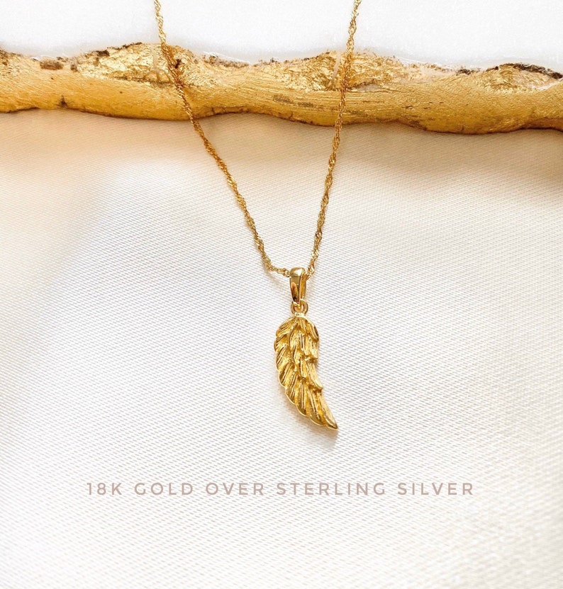K&ouml;nnte beinhalten: Eine goldene Kettenkette mit einem goldenen Engelsfl&uuml;gel-Anh&auml;nger. 18 Karat Gold &uuml;ber Sterlingsilber.