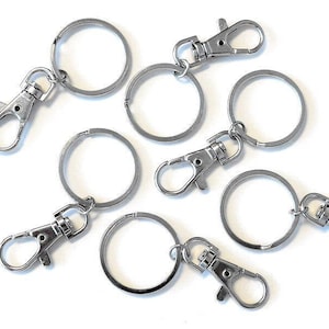 Paquete de 50 llaveros ensamblados con cierre de mosquetón, empaquetados en una bolsa de plástico.