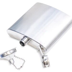 K&ouml;nnte beinhalten: Eine silberne Metallflasche mit einem Scharnierdeckel und einem kleinen Trichter, der an einer Kette befestigt ist. Die Flasche ist leer und der Deckel ist offen.