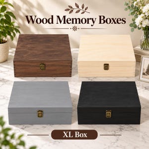 May include: Four square wood memory boxes in dark brown, light natural, gray, and black finishes. Each box features a hinged lid with a brass-toned metal latch closure. The text Wood Memory Boxes and XL Box is visible in the image.