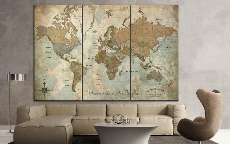 May include: A vintage-style world map printed on canvas, divided into three panels. The map is in shades of brown, green, and blue, with the text "Where our Love Has Traveled" and "Our world travels" printed below the map.