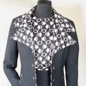 May include: A black dress suit with a white and black patterned collar. The jacket has a double breasted closure with black buttons.