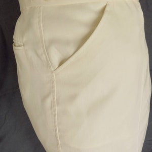 May include: A pair of white pants with a single front pocket and two buttons at the waistband.