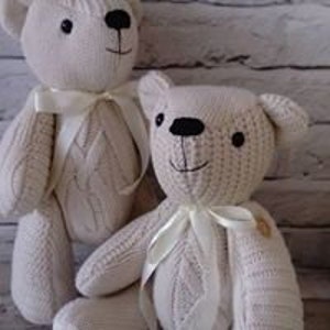 Pu&ograve; includere: Due orsacchiotti di peluche di lana bianca con occhi e nasi neri. Entrambi gli orsacchiotti hanno un nastro di raso bianco legato intorno al collo.