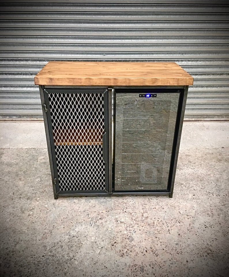 Op de afbeelding: Een zwarte metalen kast met een houten blad en een glazen deur wijnkoeler. De kast heeft een draadgaasdeur aan de linkerkant.