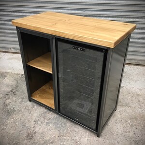 May include: A black metal cabinet with a wooden top and a built-in wine cooler. The cooler has a glass door and a digital display.