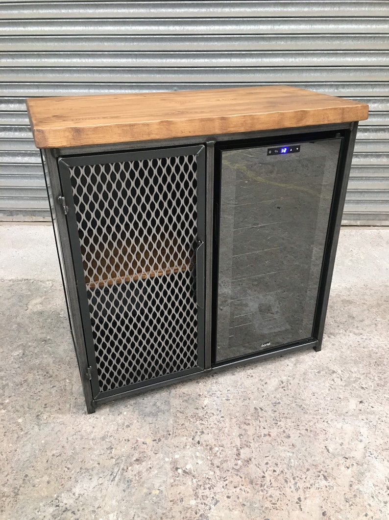 Op de afbeelding: Een zwarte metalen kast met een houten blad en een glazen deur wijnkoeler. De kast heeft een draadgaasdeur aan de linkerkant.