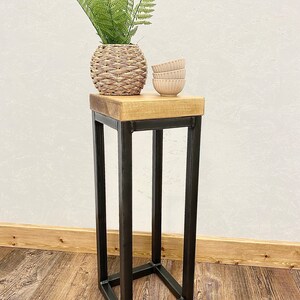 Industrial metal and wood narrow side table shown in modern decor