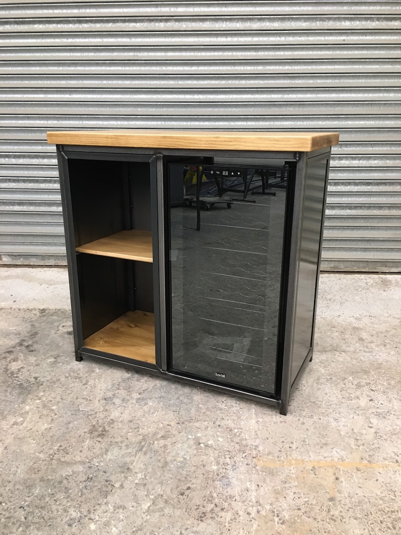 May include: A black metal cabinet with a glass door and a wooden top. The cabinet has a shelf inside and a wine cooler behind the glass door.