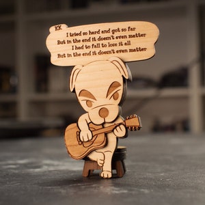 以下が含まれることがあります： ギターを弾いている犬のキャラクターのウッドフィギュア。フィギュアは、「一生懸命努力してここまで来たけど、結局は関係ない。すべてを失うために落ちなければいけなかった。結局は関係ないんだ。」という歌詞の吹き出しを持っています。