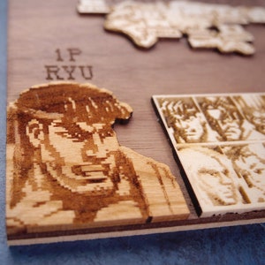 May include: A wooden plaque featuring a pixelated image of a video game character. The character is a man with dark hair and a serious expression. The text "1P RYU" is engraved on the plaque.