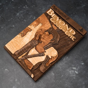 May include: A wooden game case for the Playstation 2 game Beyond Good & Evil. The case is made of dark wood with a light wood inlay of the game's main character, a woman with short brown hair, holding a weapon.