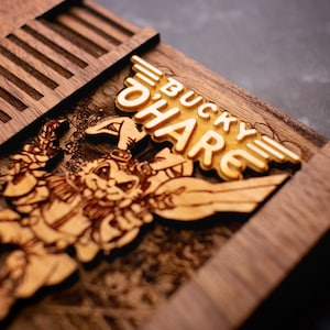 May include: A wooden box with a cutout design of a cartoon rabbit character. The box is labeled "Bucky O'Hare" in gold lettering.