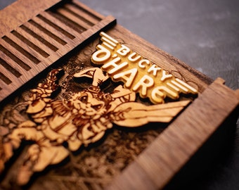 May include: A wooden box with a cutout design of a cartoon rabbit character. The box is labelled "Bucky O'Hare" in gold lettering.