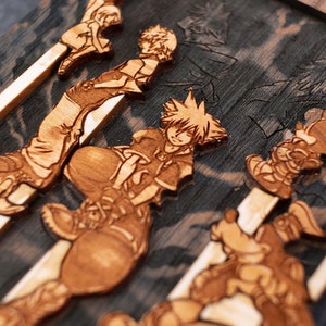Puede incluir: Una pieza de arte de pared de madera con varios personajes de la serie de videojuegos Kingdom Hearts. Los personajes est&aacute;n tallados en la madera y pintados en tonos marrones. La pieza es una excelente manera de mostrar tu amor por el juego.