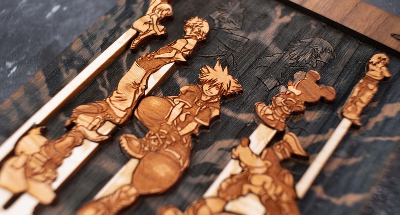 Puede incluir: Una pieza de arte de pared de madera con varios personajes de la serie de videojuegos Kingdom Hearts. Los personajes est&aacute;n tallados en la madera y pintados en tonos marrones. La pieza es una excelente manera de mostrar tu amor por el juego.