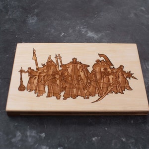 Puede incluir: Una placa de madera con una imagen grabada con l&aacute;ser de un grupo de personajes de un juego de fantas&iacute;a o una pel&iacute;cula. Los personajes est&aacute;n representados de pie, con espadas y otras armas.
