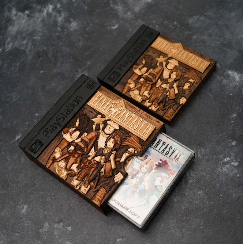 May include: A wooden box with a carved image of the Final Fantasy IX characters and the PlayStation logo. The box is open and a Final Fantasy IX game cartridge is inside.