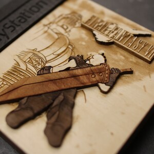 K&ouml;nnte beinhalten: Ein h&ouml;lzerner PlayStation-Spielekoffer mit einem Laser-Cut-Design eines Charakters aus Final Fantasy VII. Der Koffer ist aus hellem Holz und verf&uuml;gt &uuml;ber ein braunes Schwert und einen schwarzen Charakter.