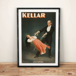 Puede incluir: Póster vintage que anuncia un espectáculo de magia de Kellar, con un hombre de esmoquin levitando a una mujer con un vestido rojo. El póster dice "KELLAR" y "LEVITATION."
