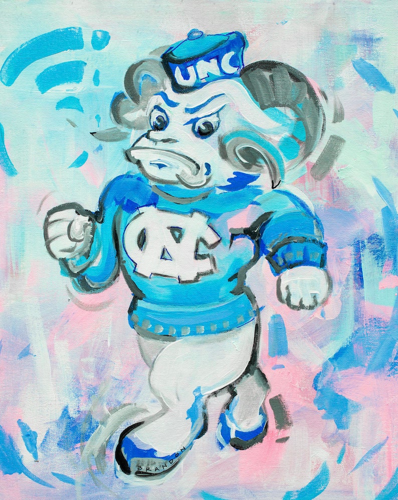Pu&ograve; includere: Una mascotte di ariete di cartone animato blu e bianco che indossa un cappello blu con le lettere "UNC" su di esso. L'ariete indossa un maglione blu con un logo "NC" bianco. Lo sfondo &egrave; un mix di blu, rosa e bianco.