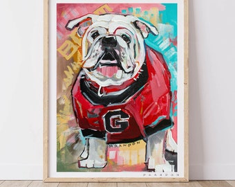 May include: A colorful painting of a white bulldog wearing a red and black jersey with a large white "G" on the front. The bulldog is looking directly at the viewer. The background is a mix of bright colors, including pink, yellow, blue, and green.
