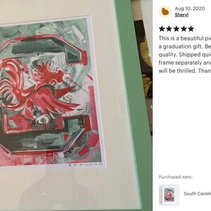 Pu&ograve; includere: Un dipinto incorniciato di un gallo rosso su sfondo verde e bianco. Il gallo &egrave; la mascotte dei Gamecocks dell'Universit&agrave; della Carolina del Sud. Il dipinto &egrave; firmato "BRANDON".