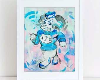 Puede incluir: Una pintura azul y blanca de un carnero de dibujos animados que lleva un sombrero azul con las letras "UNC" en él. El carnero lleva un suéter azul con las letras "UNC" en él. El fondo es una mezcla de azul, rosa y blanco.