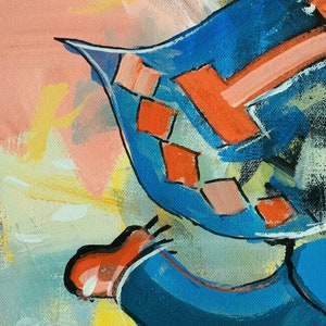 May include: A close-up of a blue and red abstract painting. The painting features a geometric pattern with a large red shape in the center.