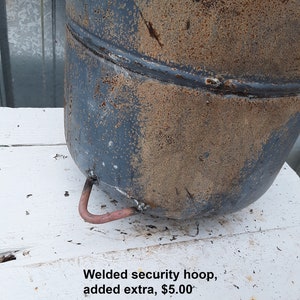 May include: A rusty metal container with a welded security hoop. The hoop is made of a thinner metal and is a different color than the container. The text "Welded security hoop, added extra, $5.00" is visible below the container.