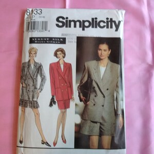 May include: Simplicity sewing pattern number 8133 for a double-breasted blazer and skirt. The pattern includes three different looks, one in a plaid fabric, one in red, and one in a beige fabric.