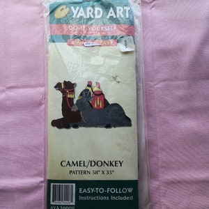 May include: A Yard Art do-it-yourself pattern for a camel and donkey. The pattern is 58 inches by 35 inches and includes easy-to-follow instructions. The pattern is on a white background with a green border. The pattern is in a plastic bag.