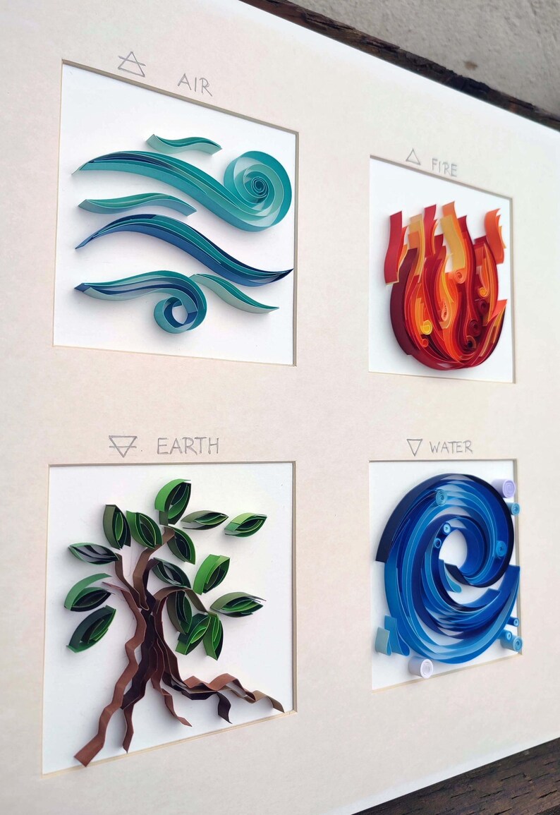 Pode incluir: Uma obra de arte emoldurada com arte de quilling de papel representando os quatro elementos: ar, fogo, terra e &aacute;gua. Cada elemento &eacute; retratado em um quadrado, com o nome e o s&iacute;mbolo do elemento acima. A obra usa tons de azul, vermelho, verde e marrom.