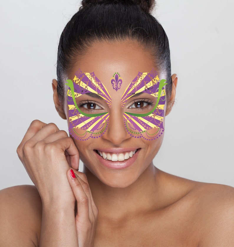 May include: A woman with a purple, yellow, and green face mask with a fleur-de-lis design. The mask is a decorative face sticker.