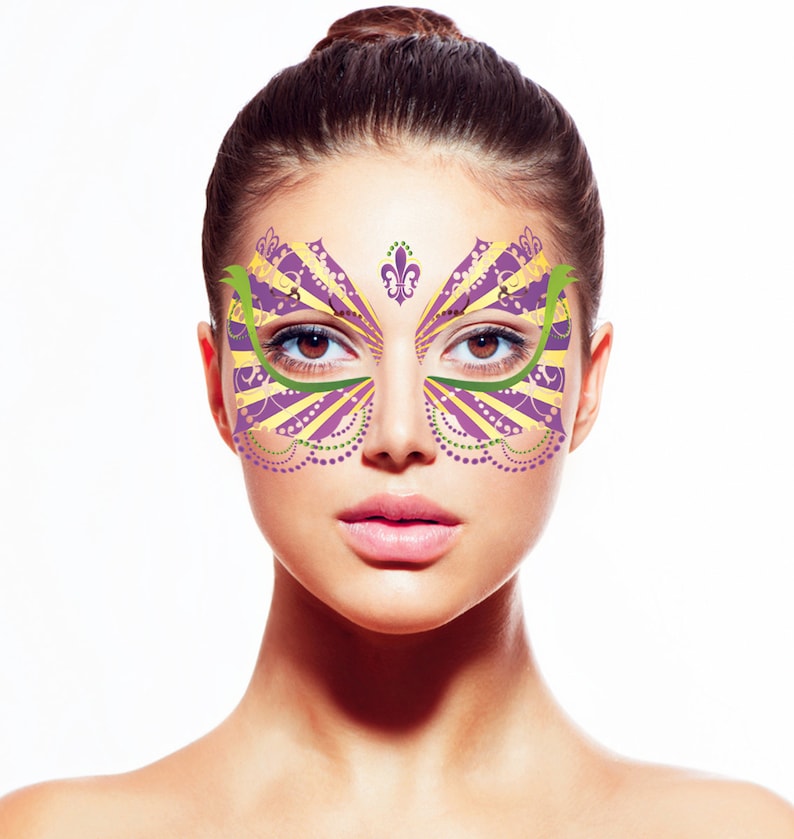 May include: A woman wearing a purple, yellow, and green face mask with a fleur-de-lis design. The mask is a masquerade style with a decorative pattern.