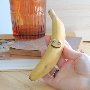 Banana con un sorriso caldo - Scultura fatta a mano OOAK - Figurina unica in argilla di carta, unica nel suo genere, arte, frutto carino e inquietante con faccia