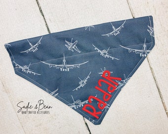 Peut inclure: Bandana bleue avec un motif d'avion blanc et le nom "Radar" brodé en rouge.
