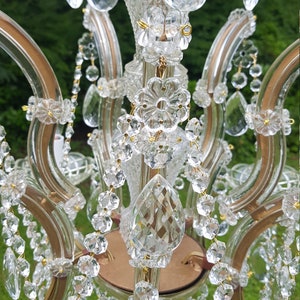 May include: A vintage chandelier with clear crystal teardrop pendants and strands of crystal beads. The chandelier has a gold-toned metal frame and decorative crystal accents, creating a classic and elegant look.