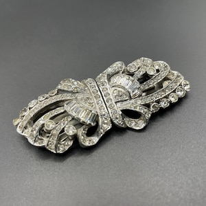 Broche vintage Art Déco de pasta de diamantes de imitación transparente y tono plateado: un broche convertible en dos broches para vestido.