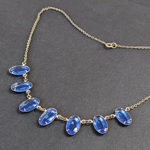 Antique / vintage sapphire blue crystal necklace, blue faceted glass oval stones, gold tone open backed settings