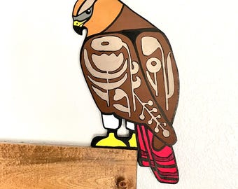 Pode incluir: Uma peça de arte de parede em madeira que retrata um falcão. O falcão é pintado em tons de castanho, bege e vermelho, com pés amarelos e um bico cinzento. A obra de arte é montada numa parede branca e numa superfície de madeira.
