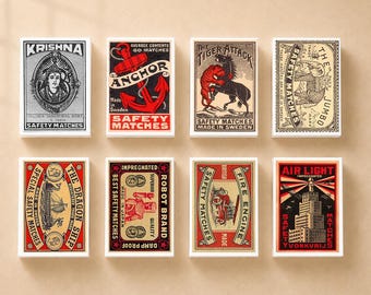 Puede incluir: Ocho cajas de cerillas rectangulares dispuestas en dos filas, cada una con ilustraciones gráficas de estilo vintage y textos que incluyen Krishna, Anchor, Tiger Attack, The Jumbo, The Dragon Ship, Robot Brand, Fire Engine y Air Light.